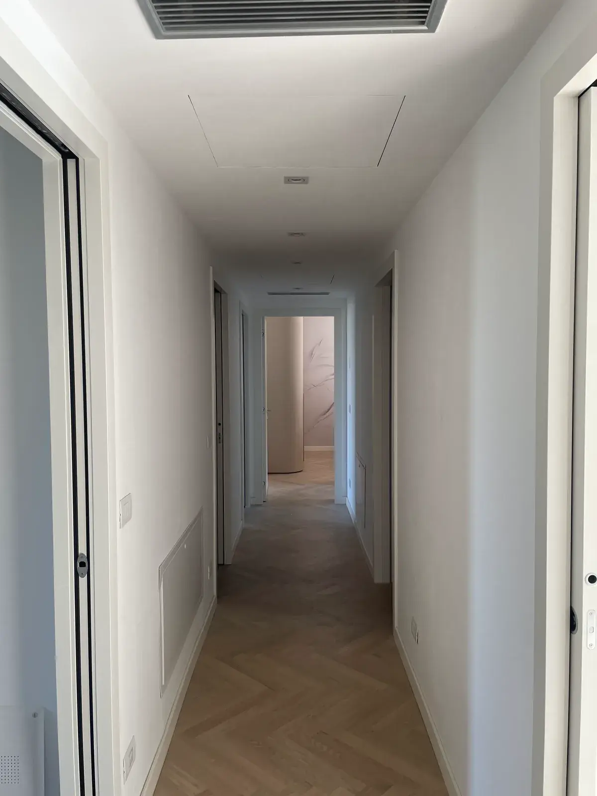 Corridoio con parquet a spina e illuminazione a incasso a soffitto