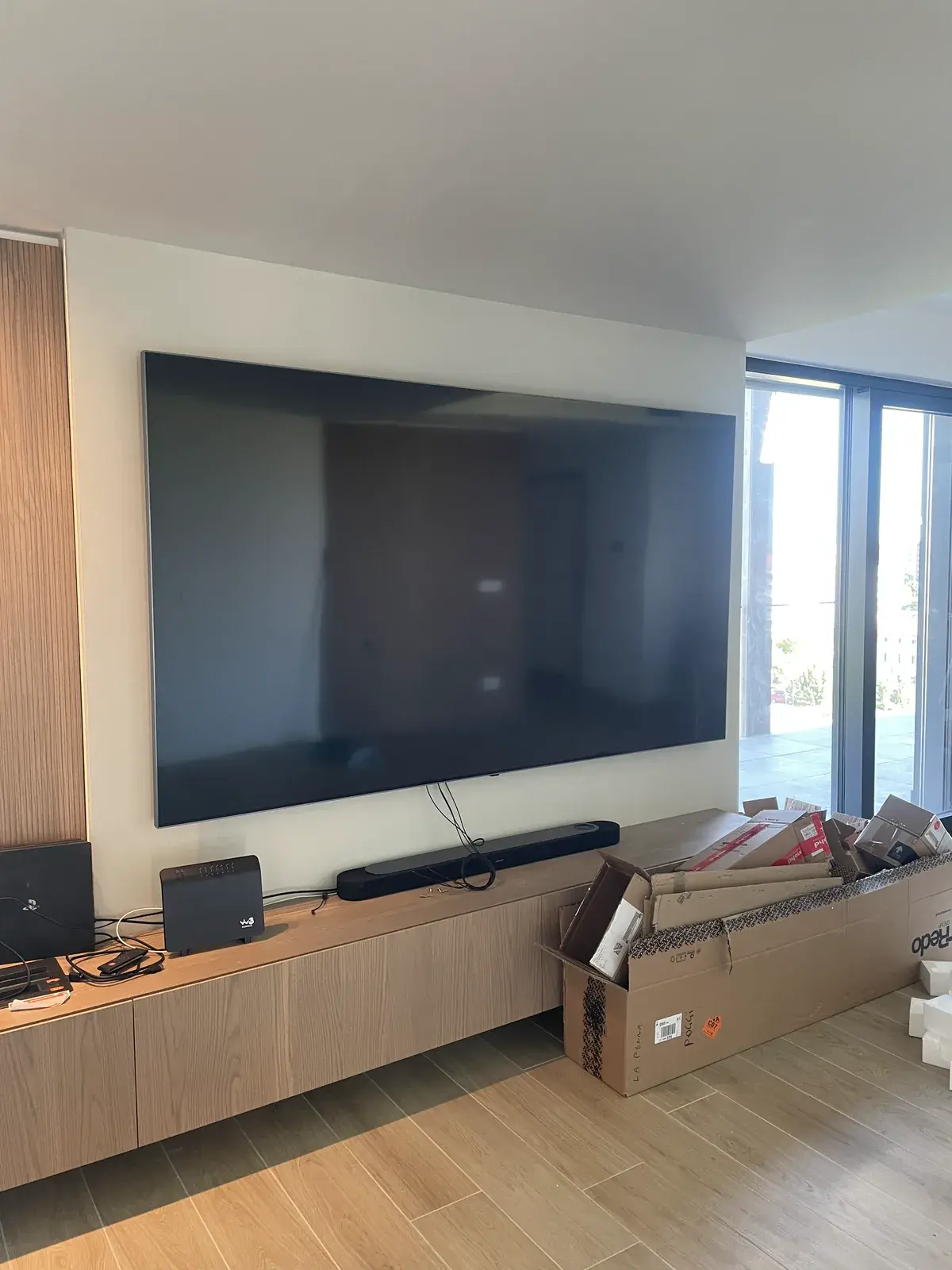 Parete TV con pannello in legno e collegamenti nascosti a filo muro