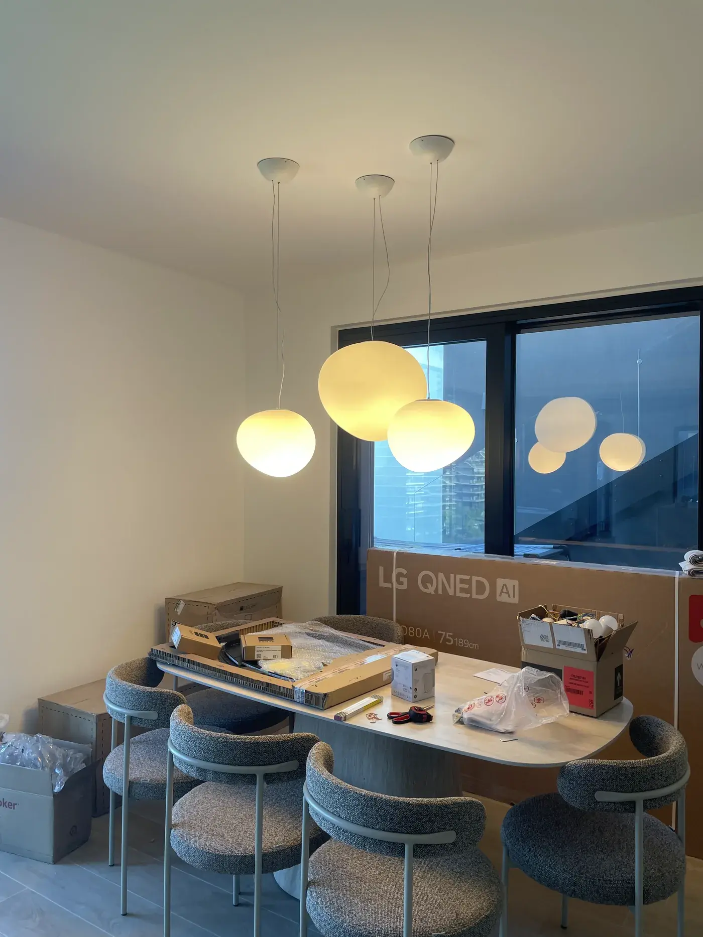Sala da pranzo con lampade a sospensione accese sopra il tavolo