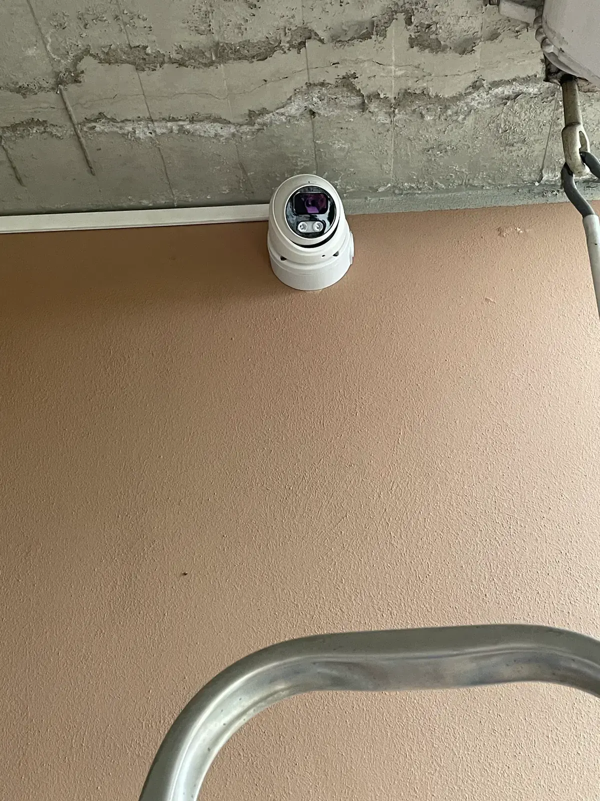 Telecamera dome per videosorveglianza installata sotto il cornicione di un edificio